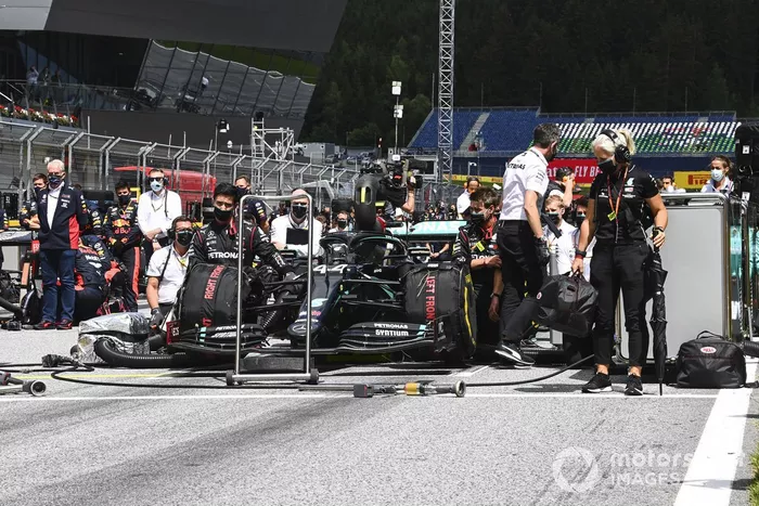 Los miembros del equipo Mercedes se arrodillan en la parrilla