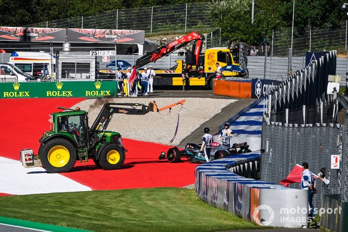 Los oficiales de pista retiran el coche de George Russell, Mercedes W13, tras un accidente en la Q3