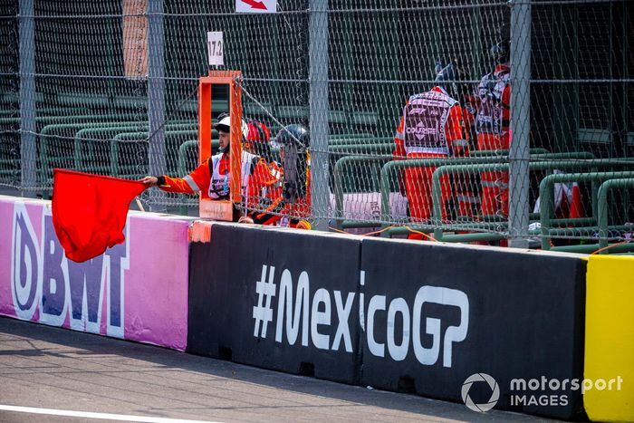 Un oficial de pista agita la bandera roja