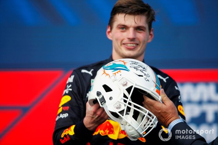 Max Verstappen, Red Bull Racing, 1ª posición, recibe un casco de NFL de los Miami Dolphins en el podio