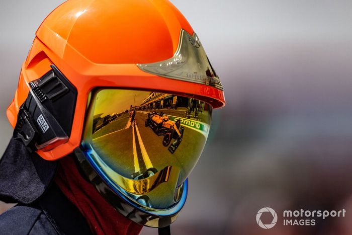 Daniel Ricciardo, McLaren MCL35M, reflejado en el casco de un comisario