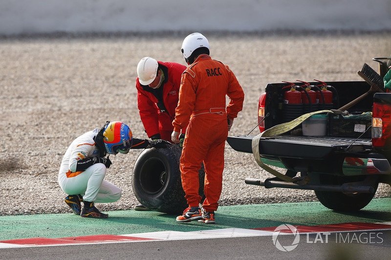 Fernando Alonso, McLaren, inspects the wheel