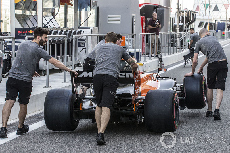 Des mécaniciens McLaren avec la MCL32 dans la voie des stands