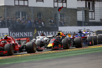 Kimi Raikkonen, Ferrari SF71H, leads Daniel Ricciardo, Red Bull Racing RB14, Marcus Ericsson, Sauber C37, and Brendon Hartley, Toro Rosso STR13, at the start as debris from the rear wing of Ricciardo flies through the air