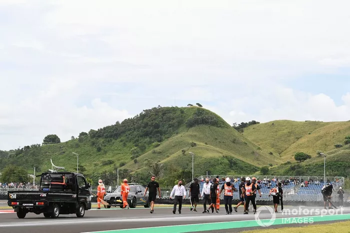 Comisarios limpiando después del fuego en la moto de Alex Rins