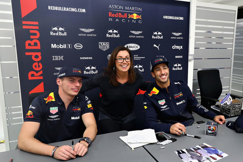 Daniel Ricciardo, Red Bull Racing, y Max Verstappen, Red Bull Racing, posan para una foto con un miembro de Red Bull Racing