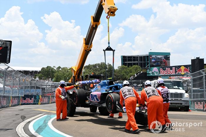 Los oficiales de pista trasladan el coche dañado de Esteban Ocon, Alpine A522, tras un accidente