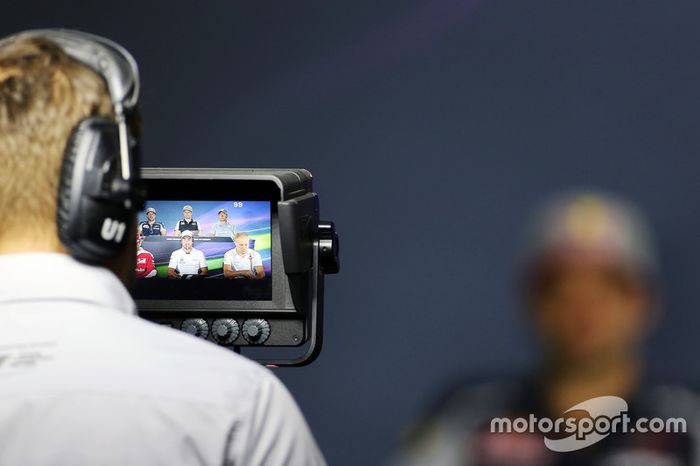 Carlos Sainz al fondo desenfocado durante una rueda de prensa en la que también está presente Fernando Alonso