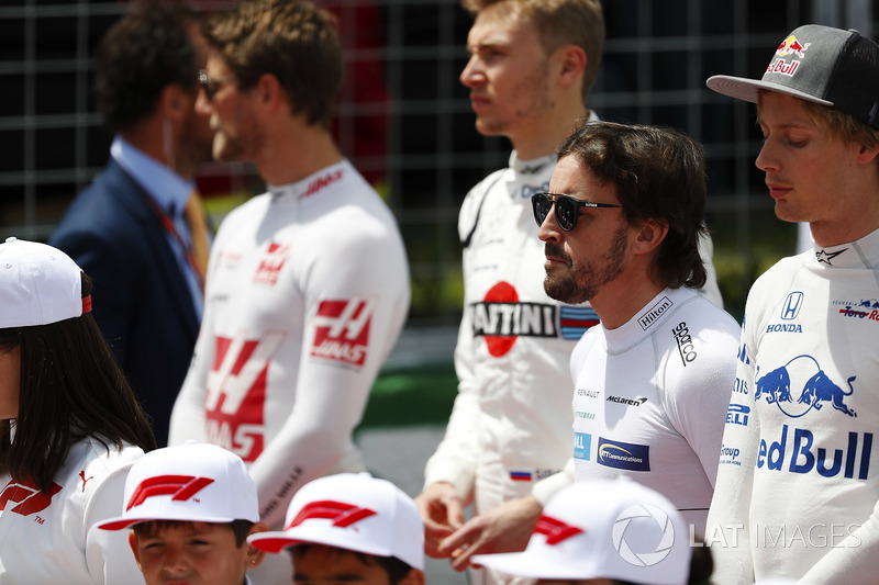 Fernando Alonso, McLaren, stands to attention for the national anthem, next to Brendon Hartley, Toro