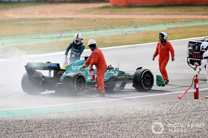 Oficiales de pista asisten a Sebastian Vettel, Aston Martin AMR22, después de que un fallo técnico produzca humo