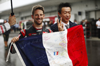 Romain Grosjean, Haas F1 Team, celebrates his qualifying result by holding a Tricolore decorated in messages.