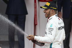 Lewis Hamilton, Mercedes AMG F1, spuit met champagne op het podium