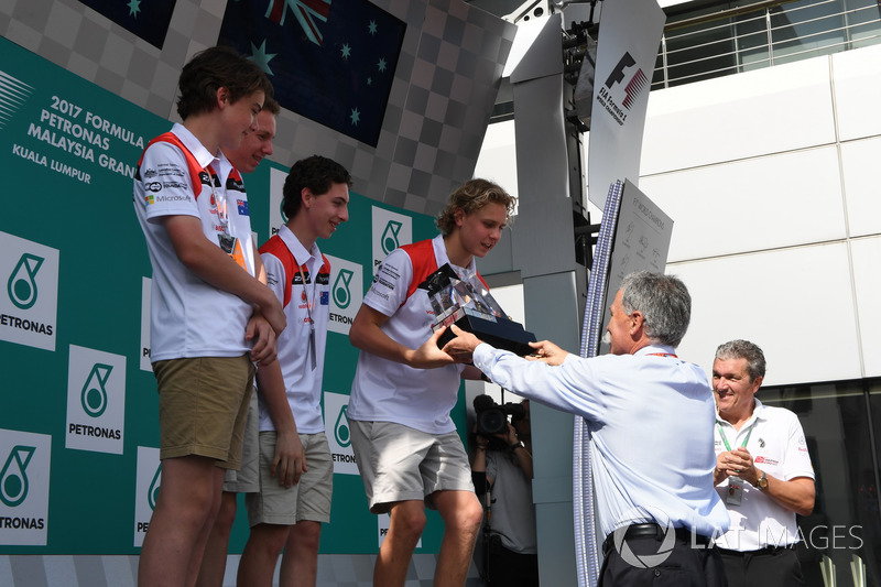 F1 in Schools students on the podium, Chase Carey, Chief Executive Officer and Executive Chairman of the Formula One Group and Andrew Denford, F1 in Schools