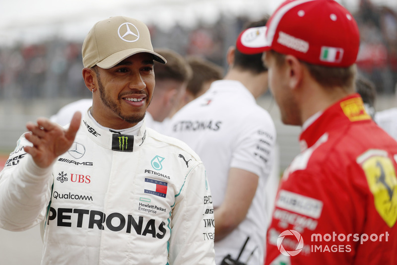 Lewis Hamilton, Mercedes AMG F1, talks with Sebastian Vettel, Ferrari, after taking Pole Position