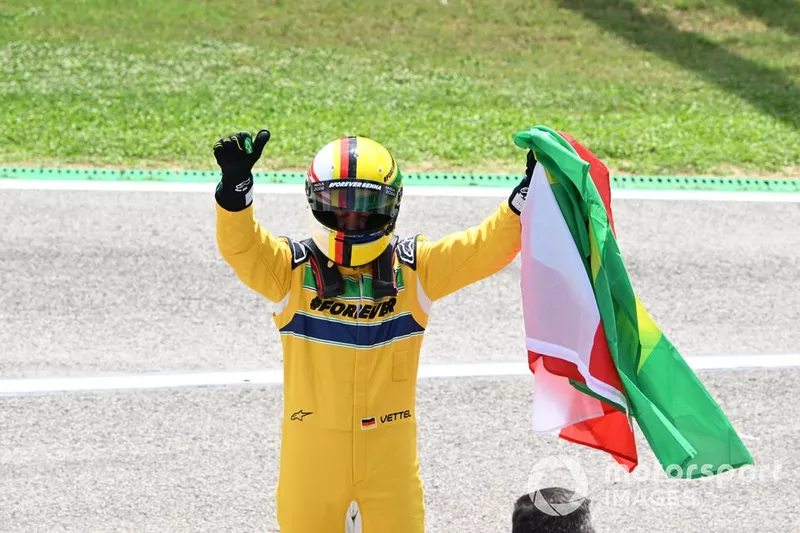 Sebastian Vettel brandit les drapeaux autrichien et brésilien après avoir conduit la McLaren MP4/8 d'Ayrton Senna.