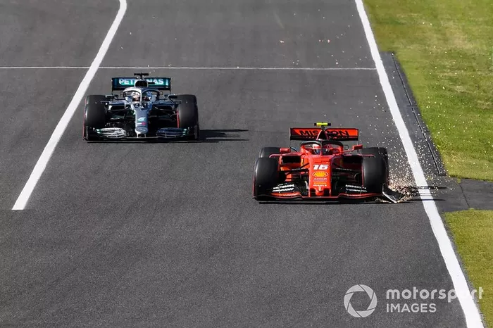 Charles Leclerc, Ferrari SF90, lidera a Lewis Hamilton, Mercedes AMG F1 W10, mientras sigue las chispas de su dañado alerón delantero