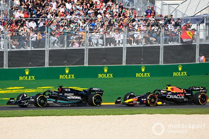 George Russell, Mercedes F1 W14, lucha con Max Verstappen, Red Bull Racing RB19, en la salida.