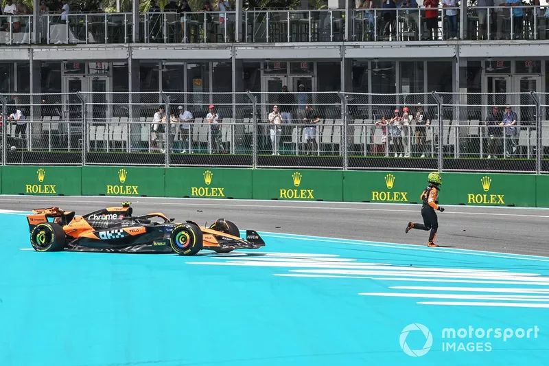 Lando Norris, McLaren MCL38, traverse la piste à pied après une chute dans le premier tour.