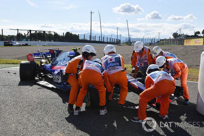 Oficiales de pista retiran el coche de Carlos Sainz Jr., Scuderia Toro Rosso STR12