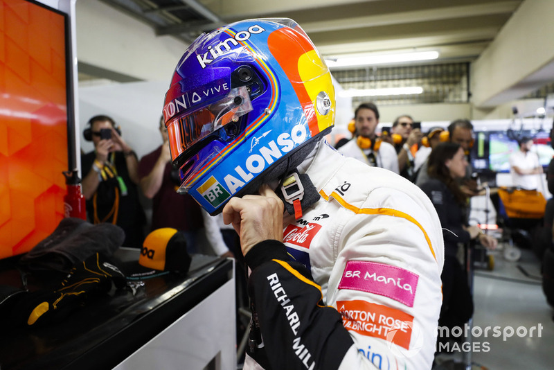 Fernando Alonso, McLaren, adjusts his crash helmet