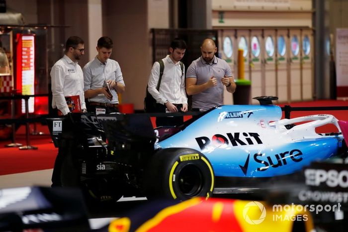 Los aficionados mirando los coches en exposición