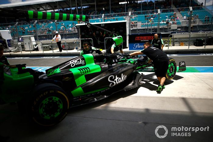 Mecánicos del Stake F1 Team Kick Sauber empujan el coche de Zhou Guanyu, Stake F1 Team Kick Sauber C44, de vuelta al garaje.