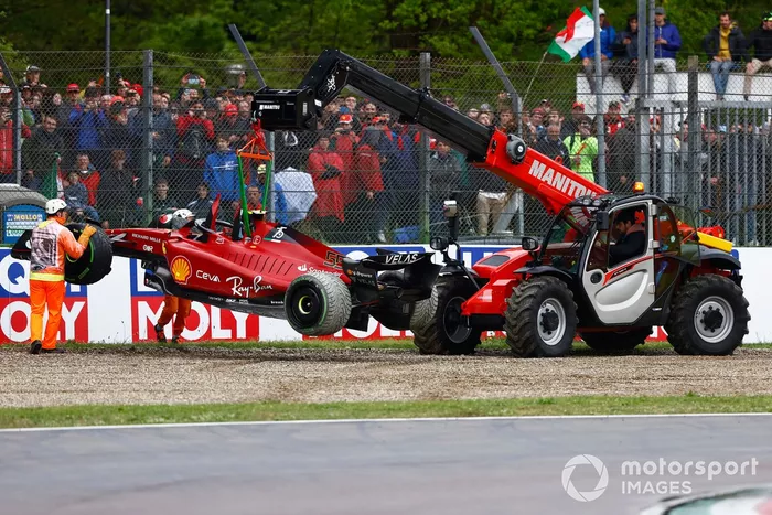 Los oficiales retiran el coche de Carlos Sainz Jr., Ferrari F1-75, de la grava tras su retirada en la primera vuelta