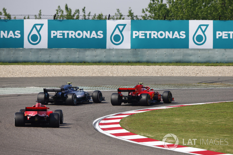 Valtteri Bottas, Mercedes AMG F1 W09, passes Kimi Raikkonen, Ferrari SF71H, pour la tête de course devant Sebastian Vettel, Ferrari SF71H