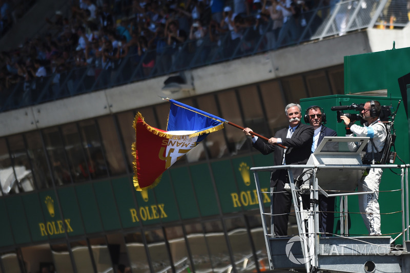 Chase Carey, FOM CEO waves the French flag to give the start of the race