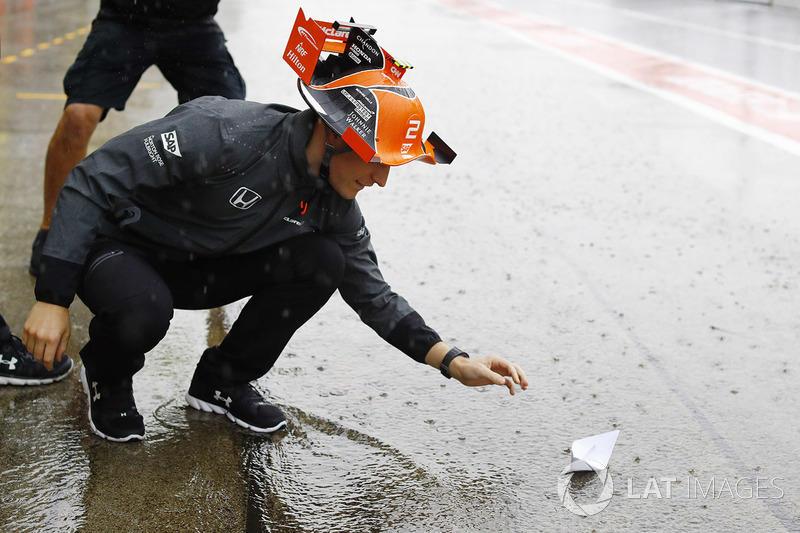 Stoffel Vandoorne, McLaren, pone un barco de papel en la corriente de agua en el pit lane