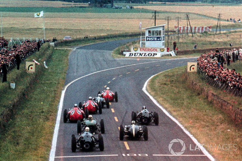 The Ferrari D246 of Phil Hill, leads Jack Brabham, Cooper Climax T53, and the two Ferrari D246 of Wolfgang von Trips, and Willy Mairesse, into the first corner after the start