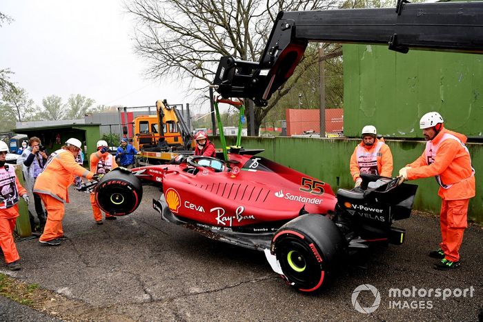 Oficiales de pista cargan el coche de Carlos Sainz Jr., Ferrari F1-75, en una grúa