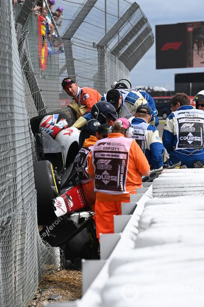 El personal médico atiende a Zhou Guanyu, Alfa Romeo C42, tras el accidente en la salida de la carrera