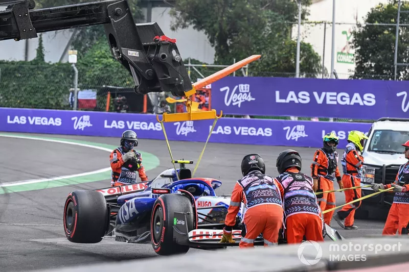 Les commissaires retirent la voiture endommagée de Yuki Tsunoda, RB F1 Team VCARB 01, d'une barrière après un accident à la fin de la Q2.