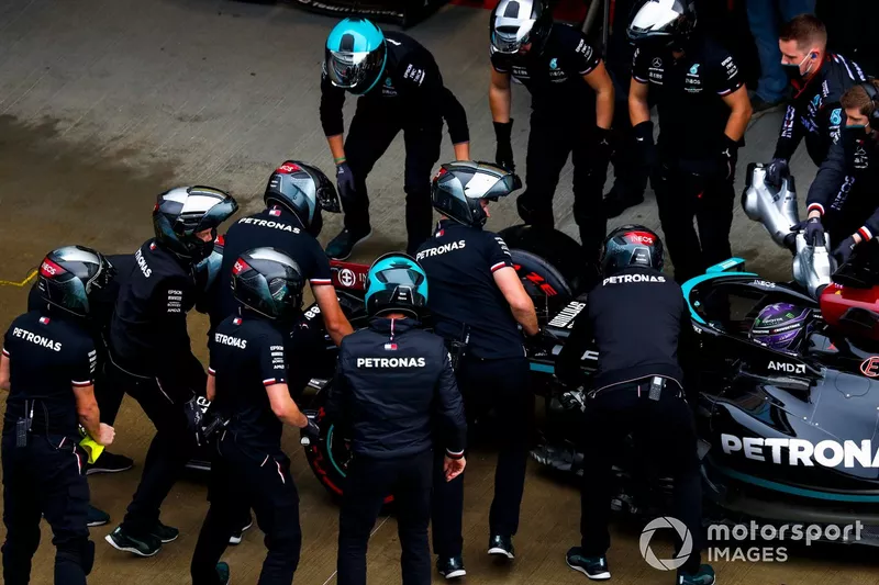 Miembros del equipo Mercedes trabajan en el coche de Lewis Hamilton, Mercedes W12, en el pit lane