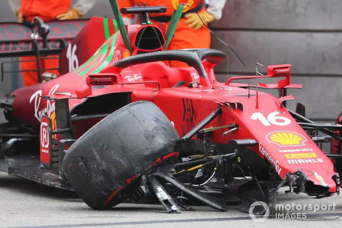 Los oficiales de pista retiran el coche de Charles Leclerc, Ferrari SF21, del circuito