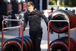 Un meccanico McLaren trascina due carrelli di pneumatici Pirelli