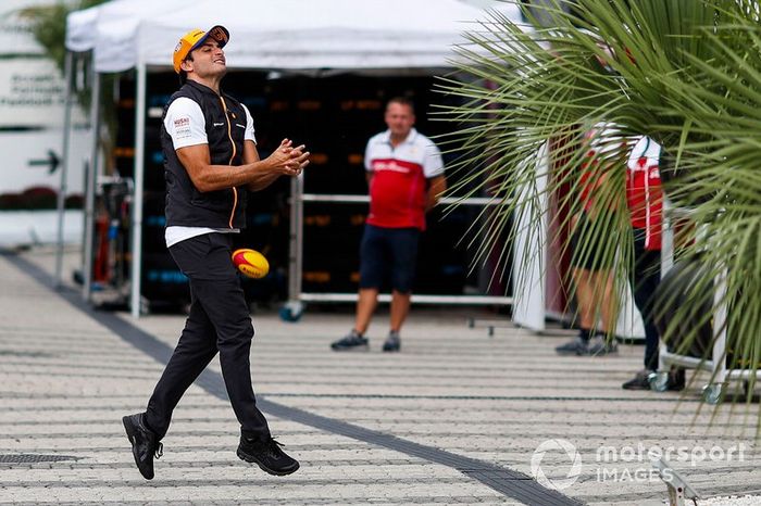 Carlos Sainz Jr., McLaren, drops a rugby ball