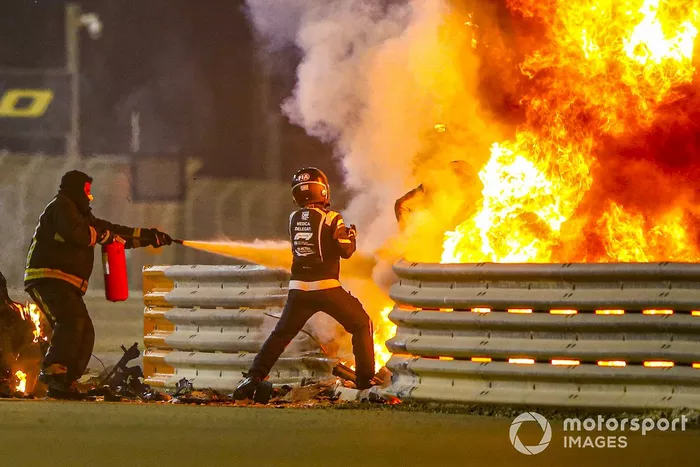 Los bomberos se encargan de las llamas y un delegado médico saca a Romain Grosjean, Haas F1 del monoplaza