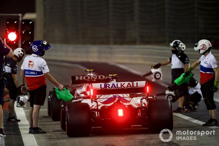 Los mecánicos refrigerando el coche de Mick Schumacher, Haas VF-21 en el pit lane