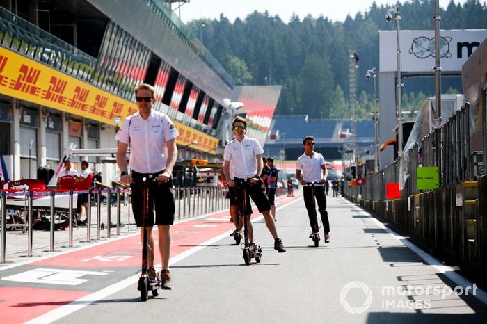 Lando Norris, McLaren y miembros de McLaren en patinetes