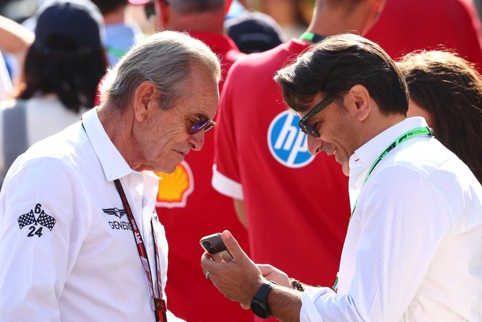Jacky Ickx talks with a guest in the Paddock