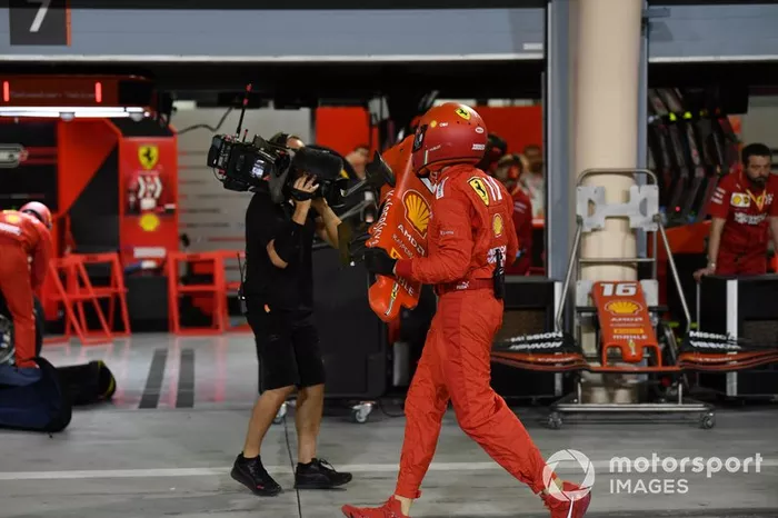 Un miembro del equipo de boxes de Ferrari con el morro dañado del coche de Sebastian Vettel, Ferrari SF90