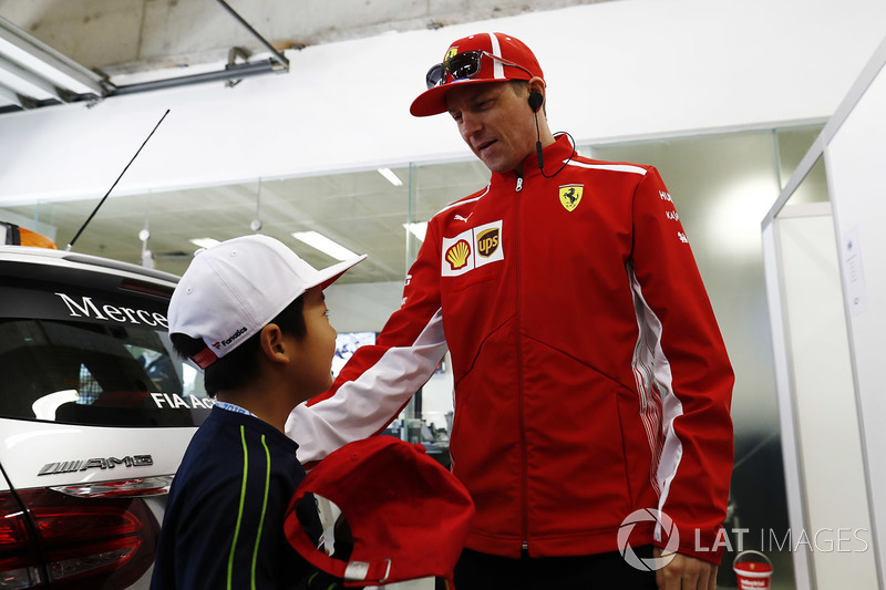 Kimi Raikkonen, Ferrari, meets a Chinese child