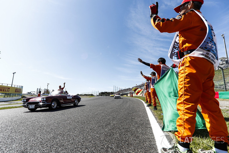 Marshals line the track as Sebastian Vettel, Ferrari, passes in the drivers parade