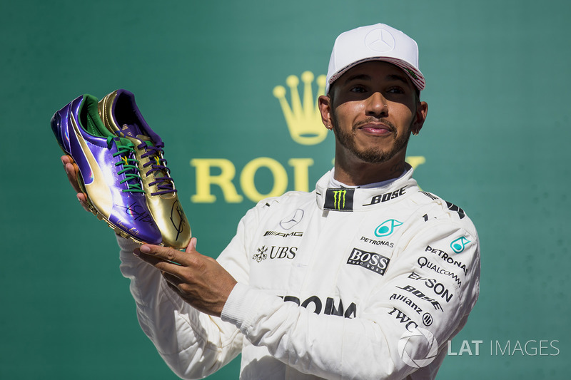 Usain Bolt le regala un par de zapatillas de atletismo al ganador de la carrera de Austin, Lewis Hamilton, Mercedes AMG F1, en el podio