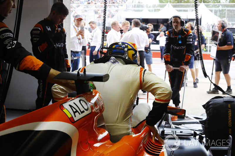 Fernando Alonso, McLaren, entre dans son cockpit dans le garage