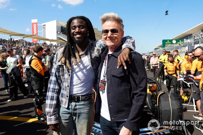 Shaboozey and Gordon Ramsey pose in front of the car of Lando Norris, McLaren MCL38, on the grid 