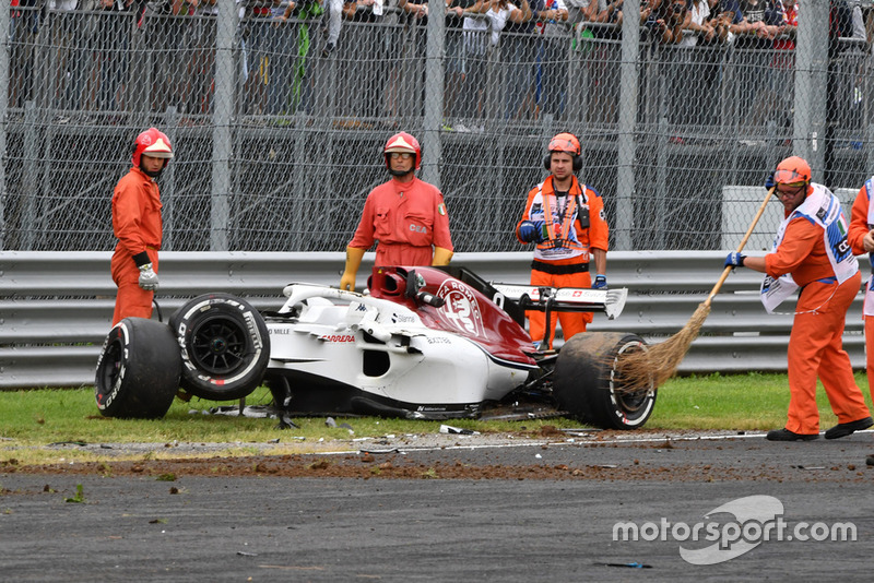 Les commissaires et la voiture accidentée de Marcus Ericsson, Alfa Romeo Sauber C37 après son crash en essais libres 2