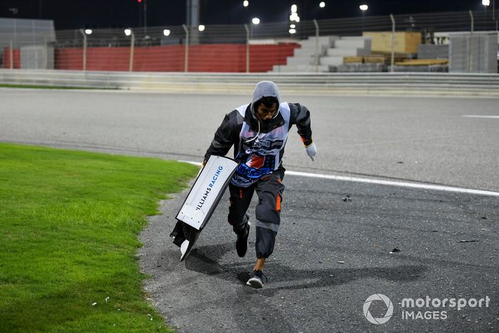 Un oficial retira el ala de Jack Aitken, Williams FW43, del circuito
